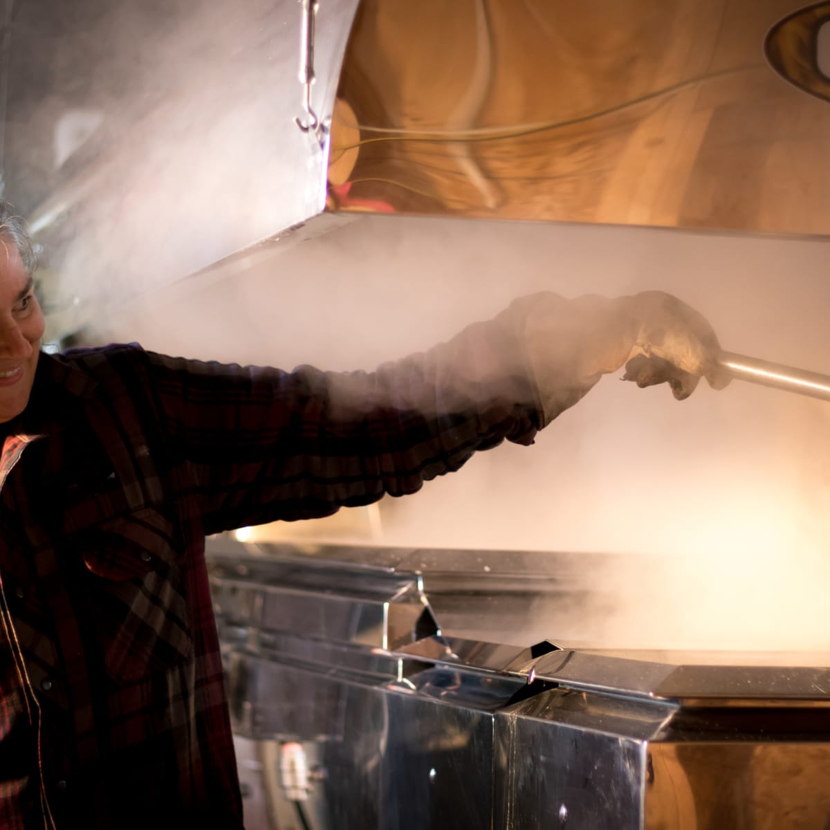 Woman preparing taffy on snow in a sugar shack.