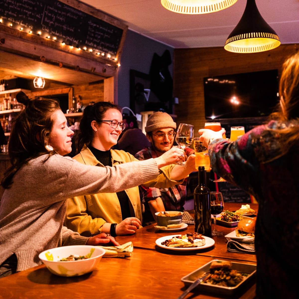 Groupe d’amis autour d’une table en train de porter un toast