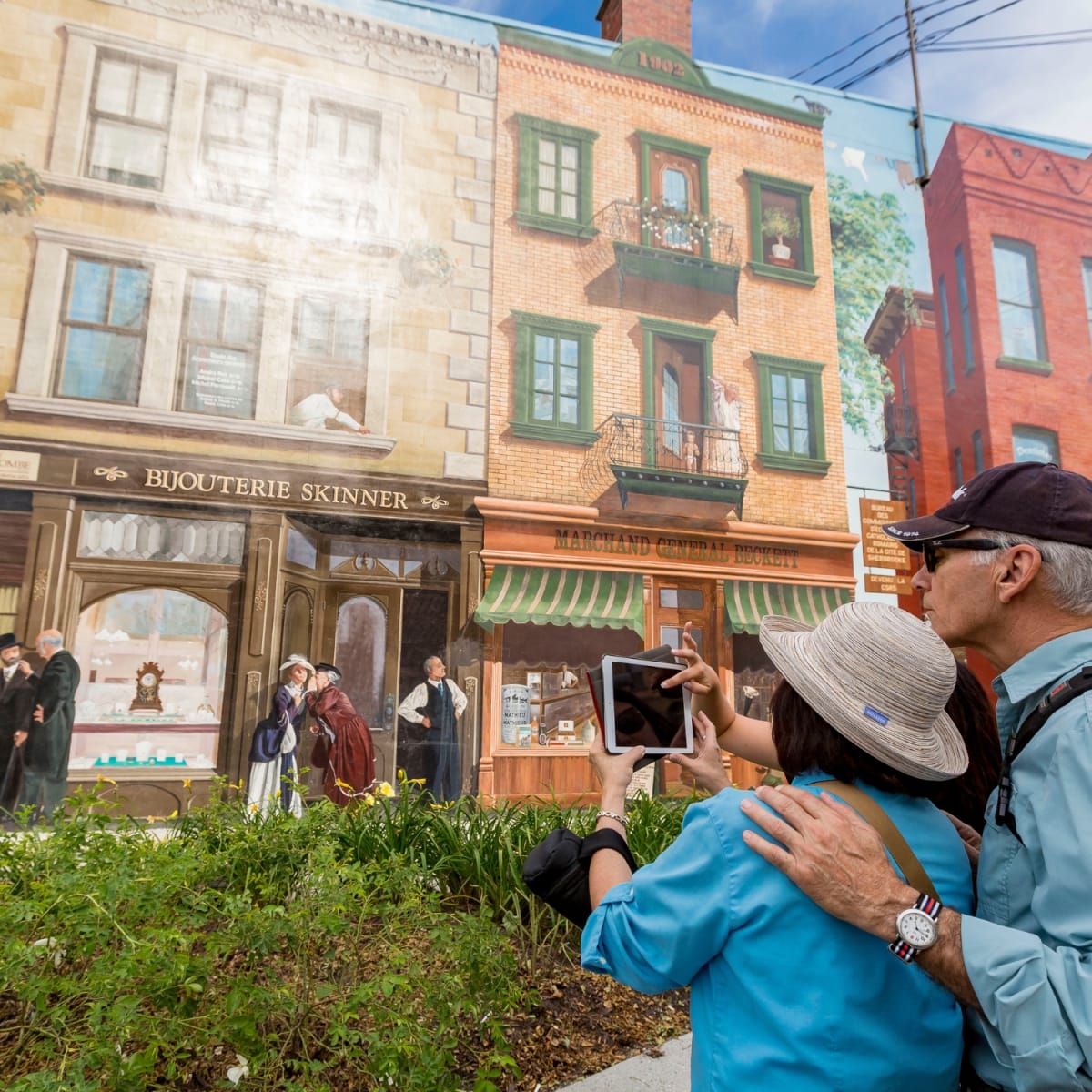 Couple taking a picture of a mural in Sherbrooke.