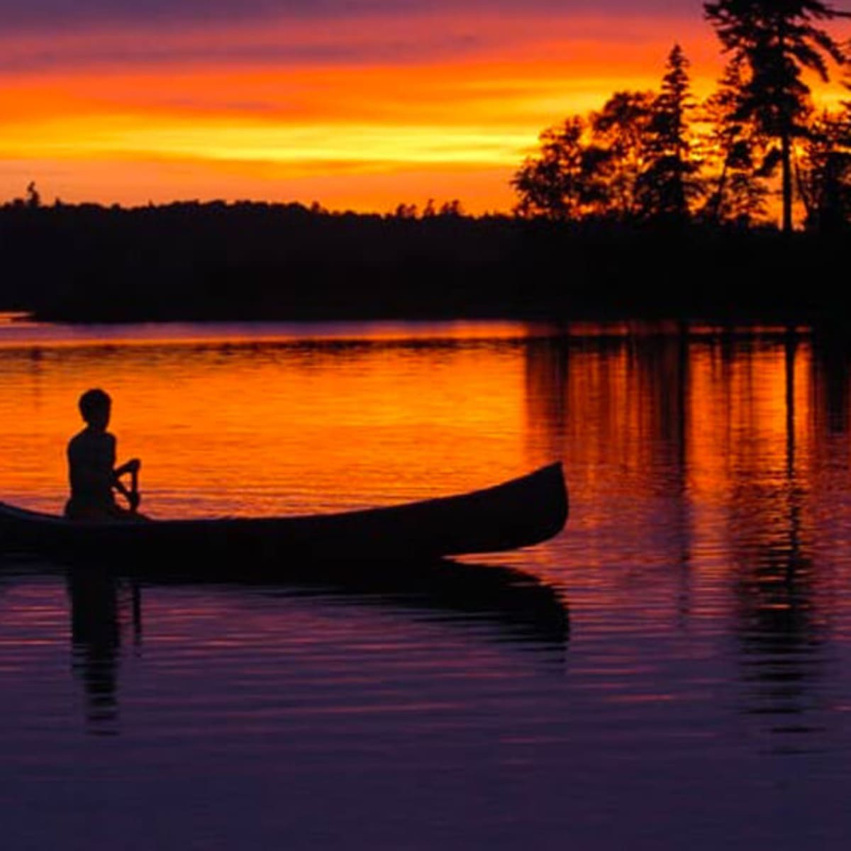 Pêche en canot au soleil levant