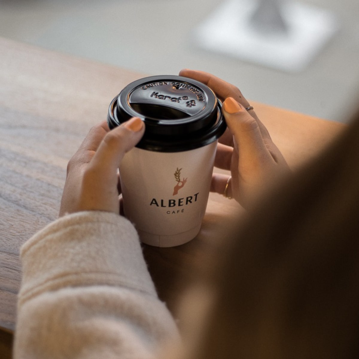 Une femme buvant un café à Albert Café et épicerie.