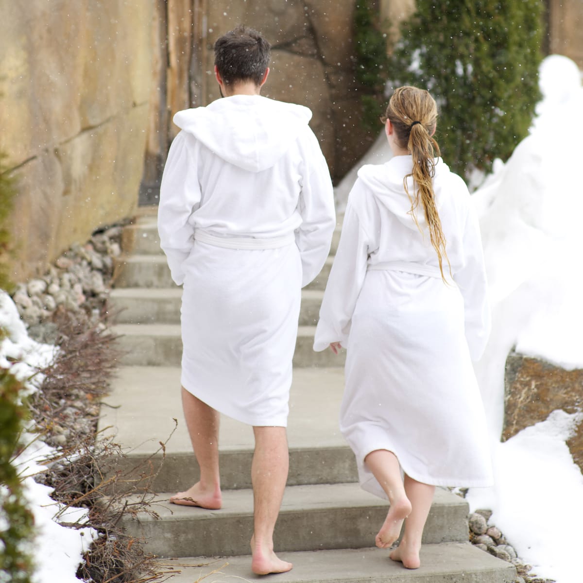 Couple walking in bathrobes at a spa.