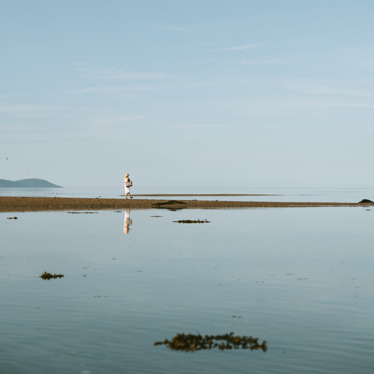 A woman at the water's edge, in the Crater and Tides Sector.