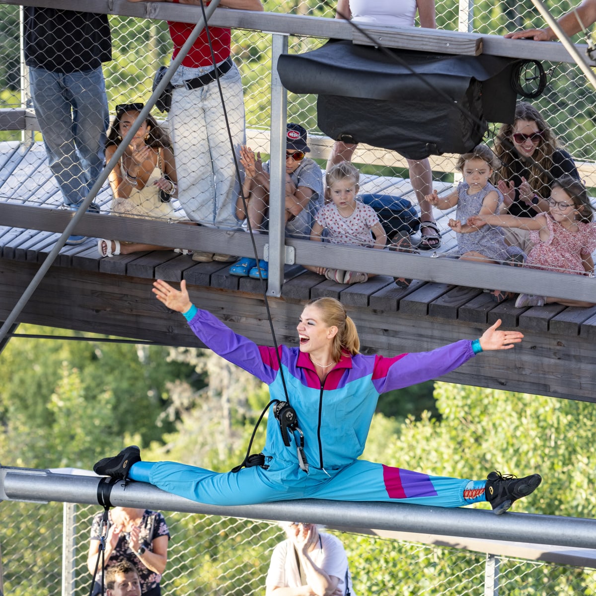 Acrobate faisant un grand écart dans les airs. 