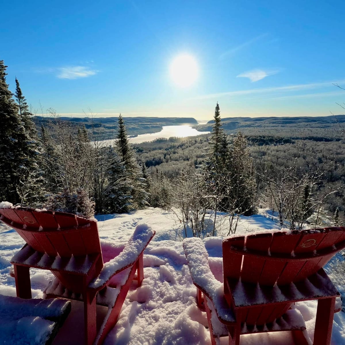 2 Adirondack chairs at the top of a lookout.