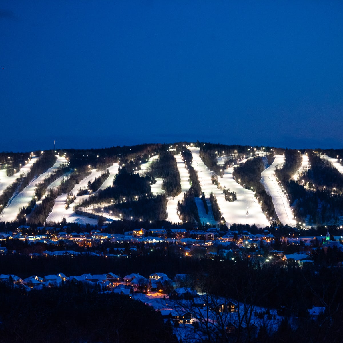 The Sommet Olympia illuminated at night.