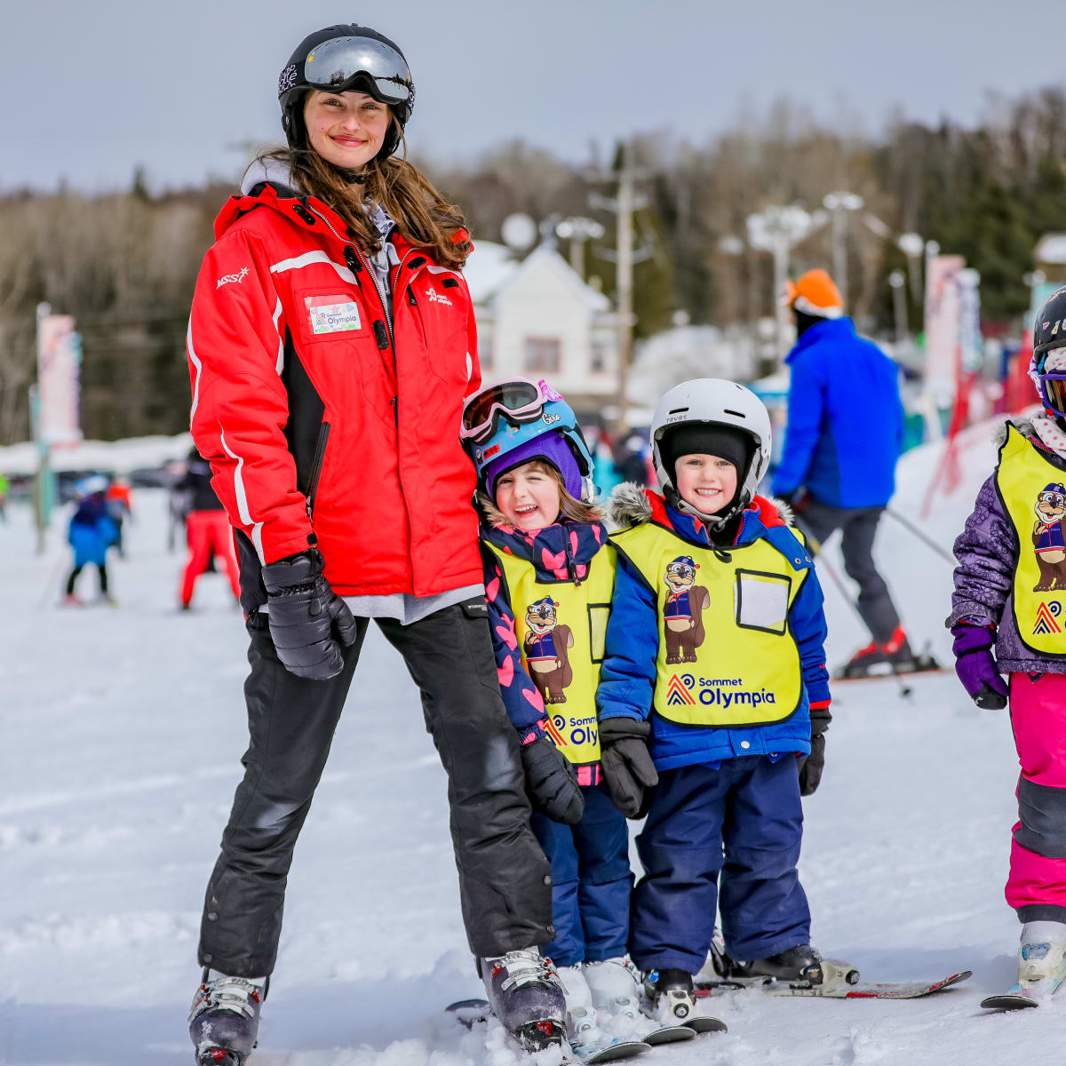 A ski instructor with three students at Sommet Olympia.