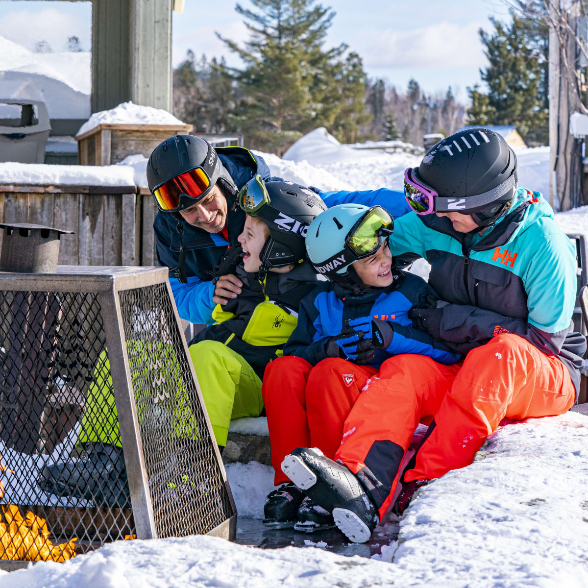 Family sitting at the foot of the mountain at Sommet Saint-Sauveur.