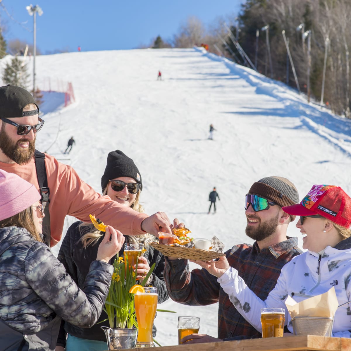 Friends are eating at the bottom of the ski mountain at Sommet Saint-Sauveur.