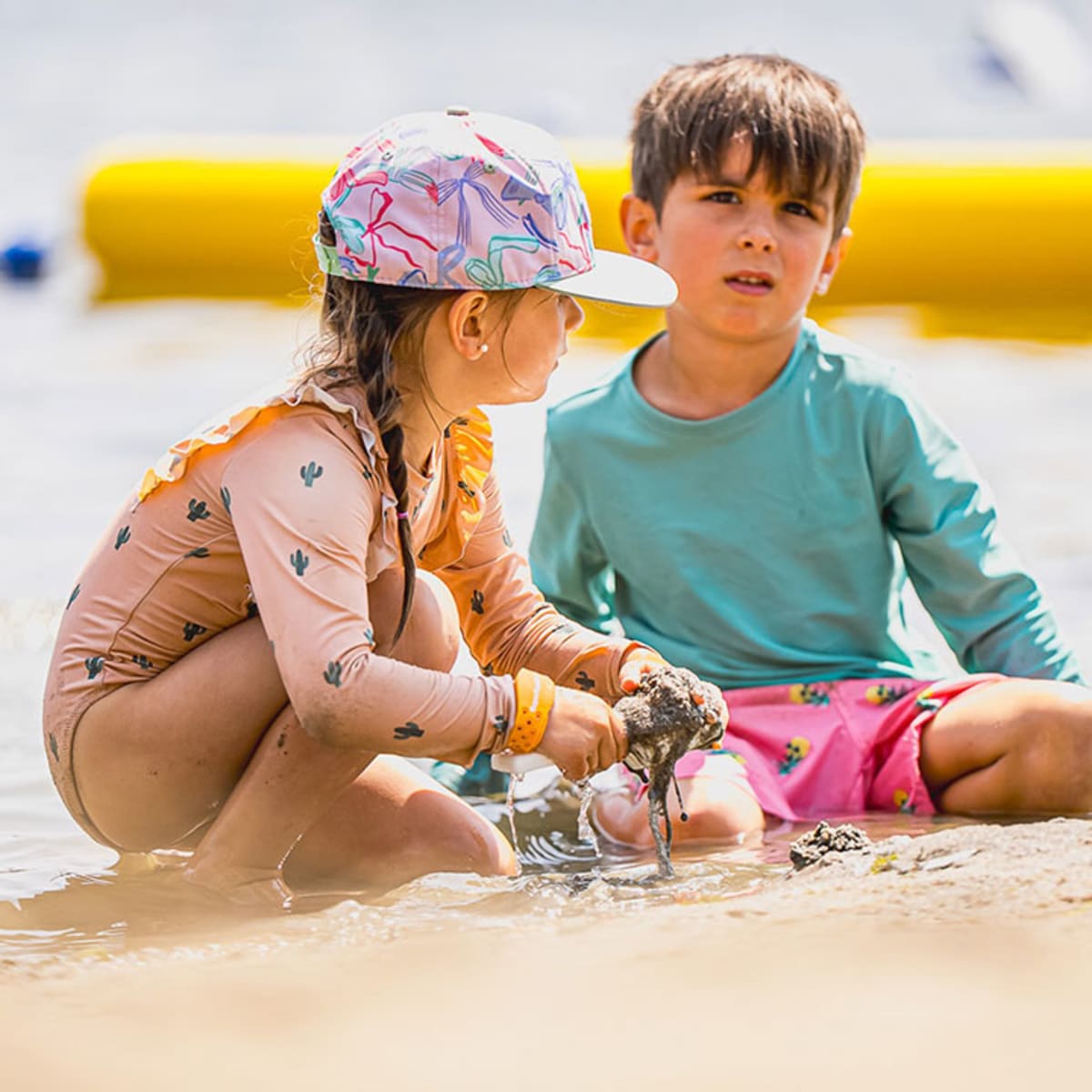 Two young children playing in the sand