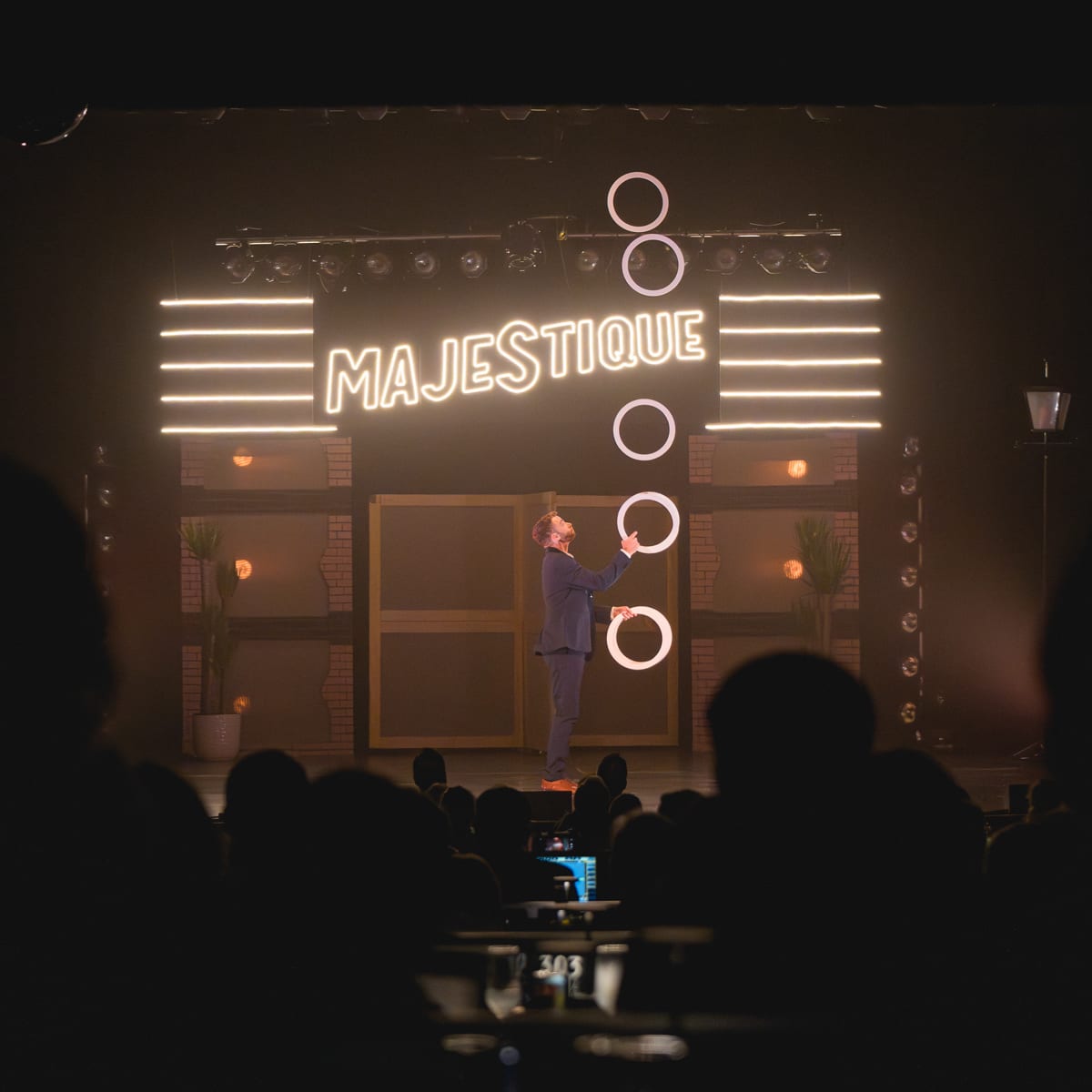 Théâtre Place Majestique a juggler is performing with small hoops on stage