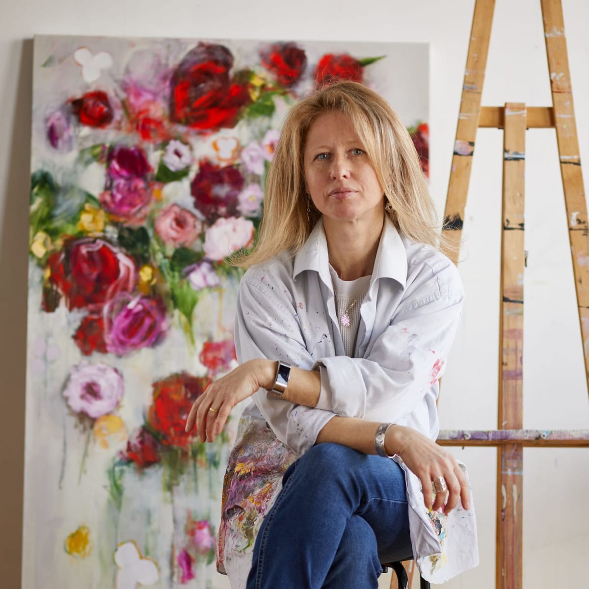 Artist sitting in front of a painting - Tour des Arts.