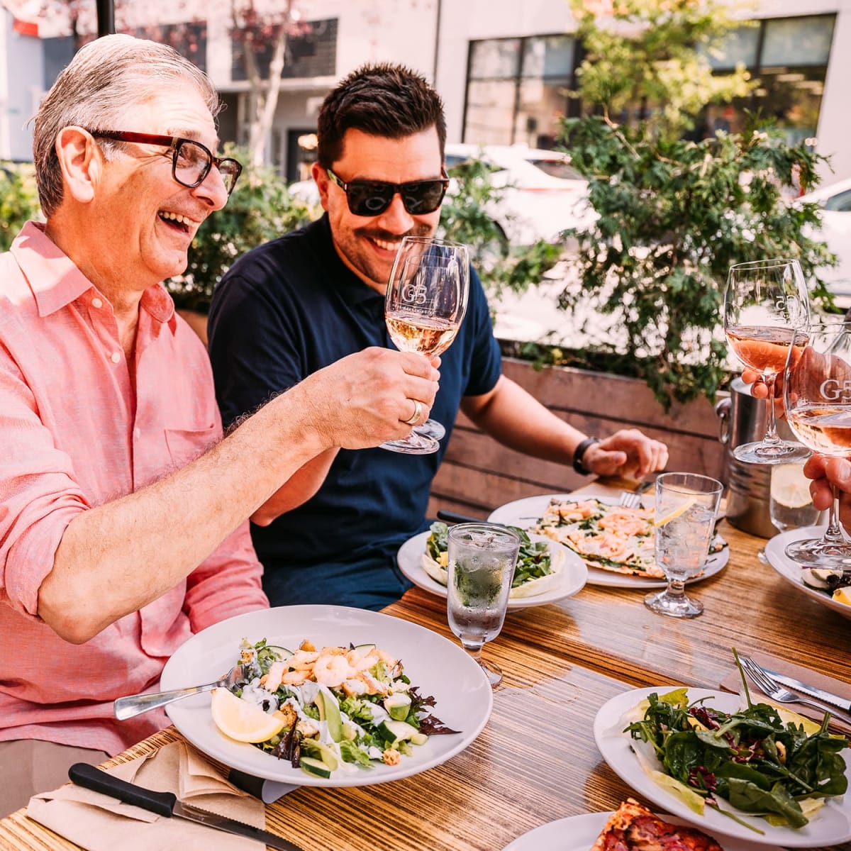 Two men raising a toast, Pizzé - Manger Boire.