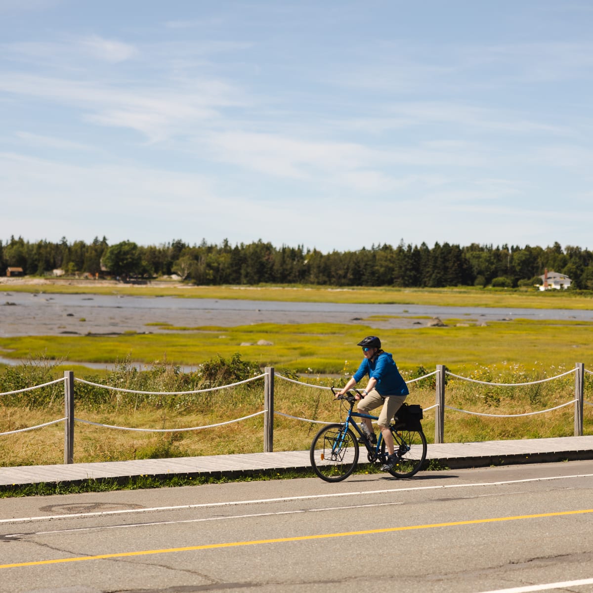 Cycliste roulant sur le bord du fleuve à marée basse au Bas-Saint-Laurent