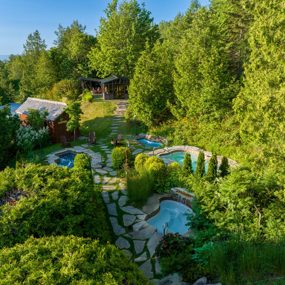 Thermal baths surrounded by lush greenery at the Auberge des Falaises.