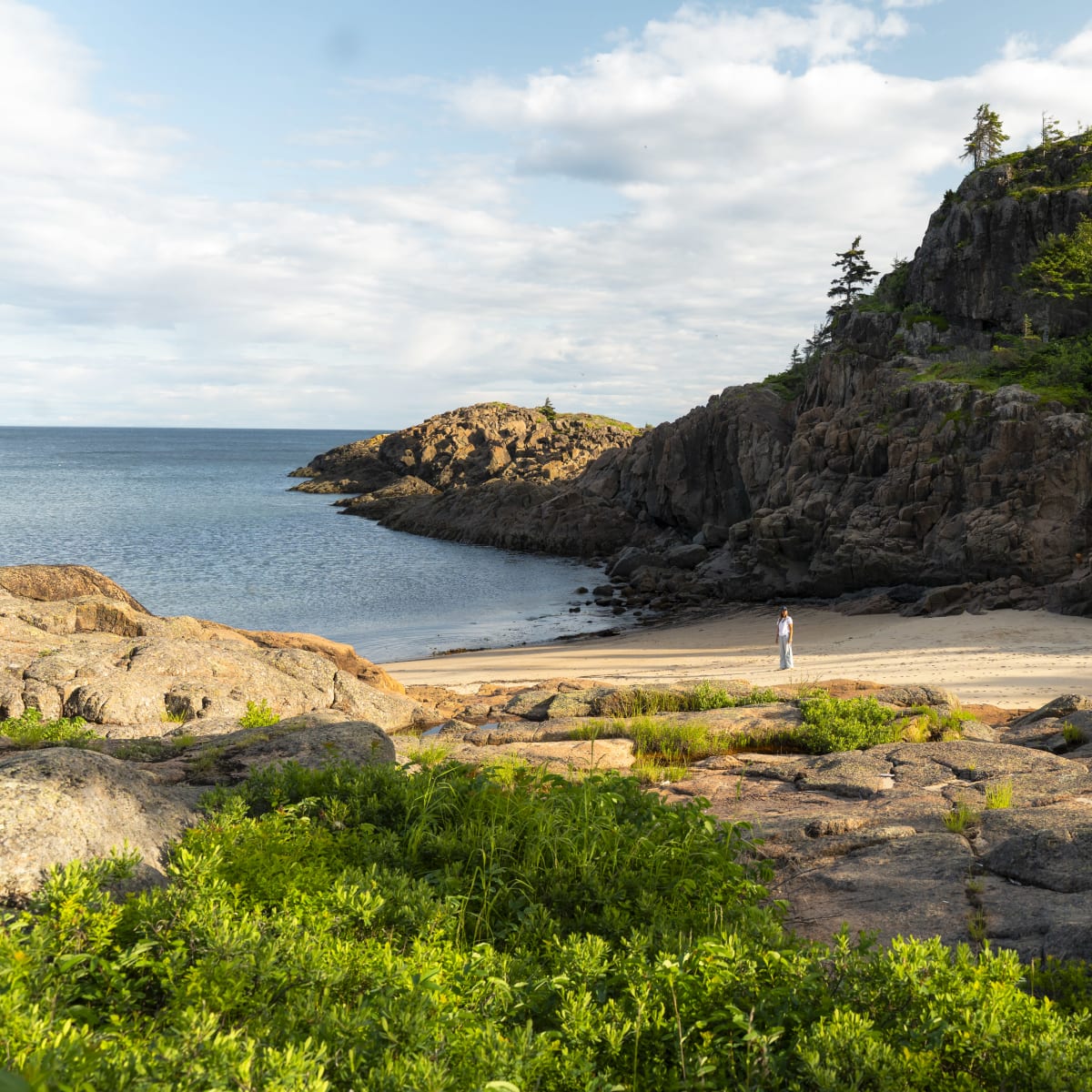 A woman by the sea in a bay.