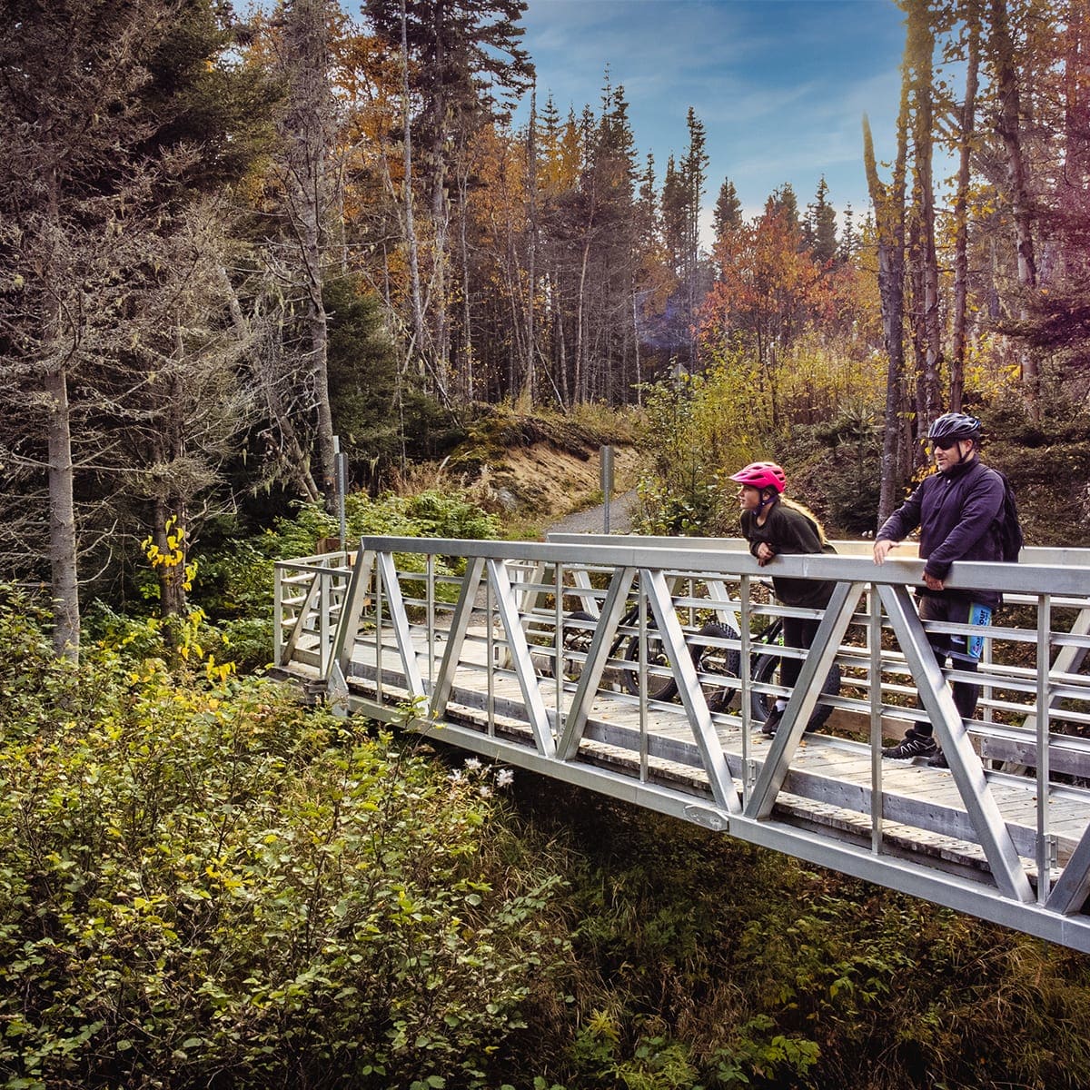 Homme et femme sur une passerelle en randonnée d'automne.