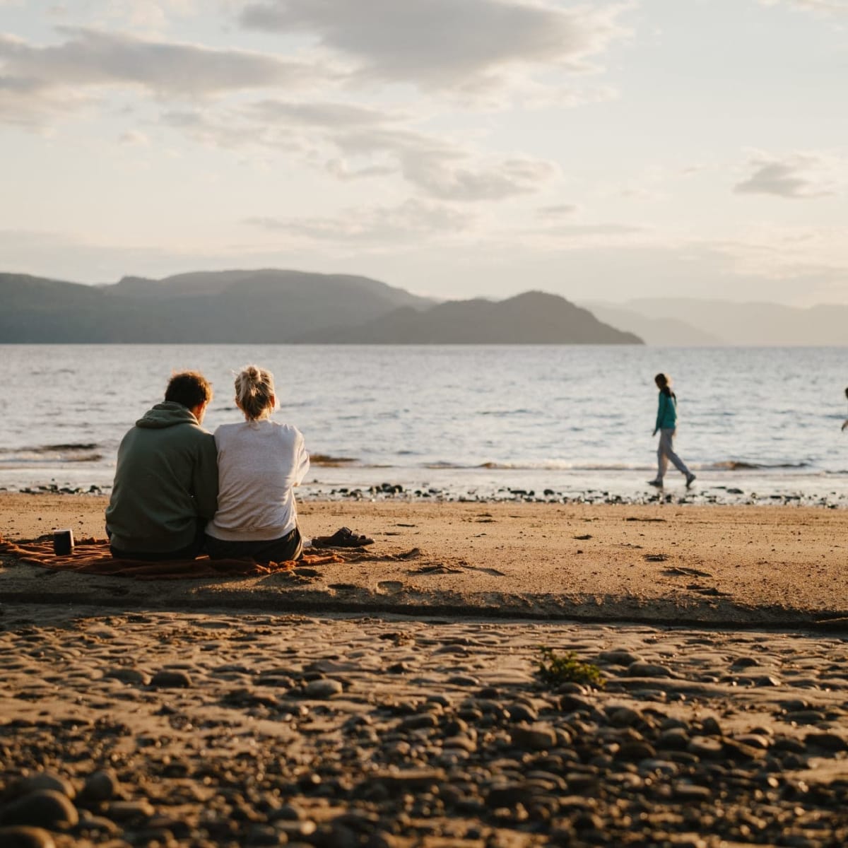 Parc national du Fjord-du-Saguenay - Couple assis sur une plage sablonneuse.