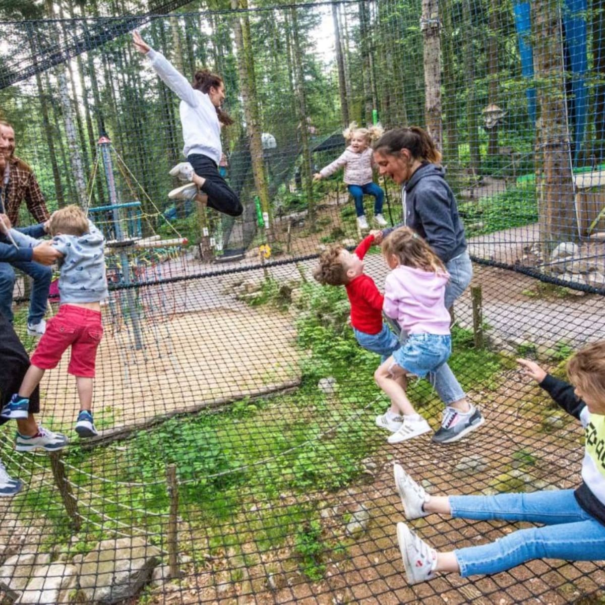 A family and their children having fun on a trampoline net at Bois des Lutins.