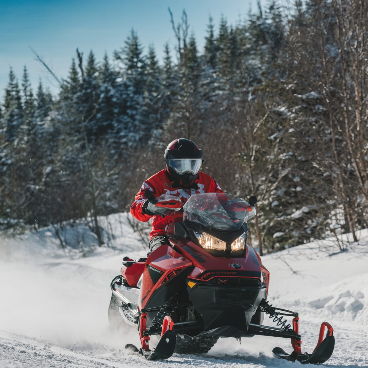 Motoneigiste dans un sentier enneigé.