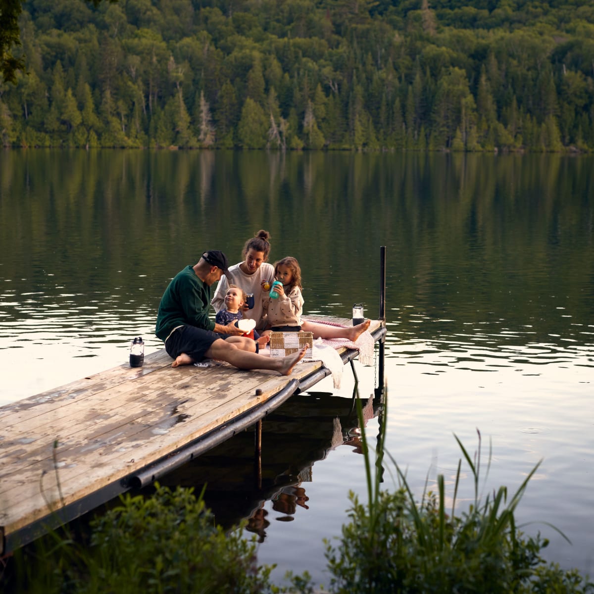 A family on a dock by the lake.