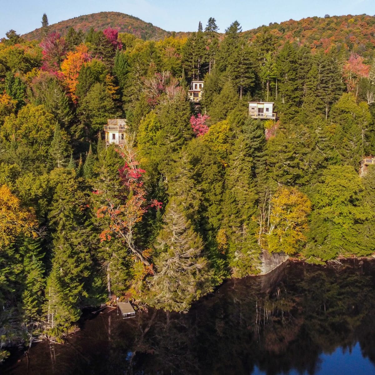Les Refuges Perchés Mont-Tremblant: colourful mountain dotted with small cabins.