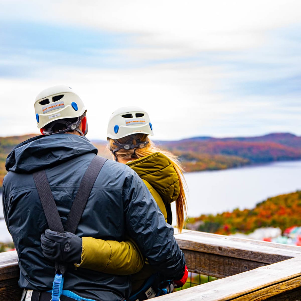 Couple wearing helmets before a zipline descent.