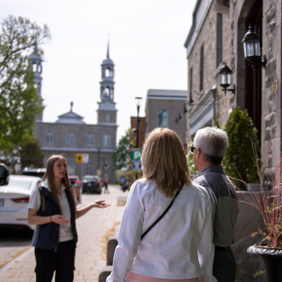 Guide interprète accompagné de deux touristes dans le vieux Saint-Eustache.