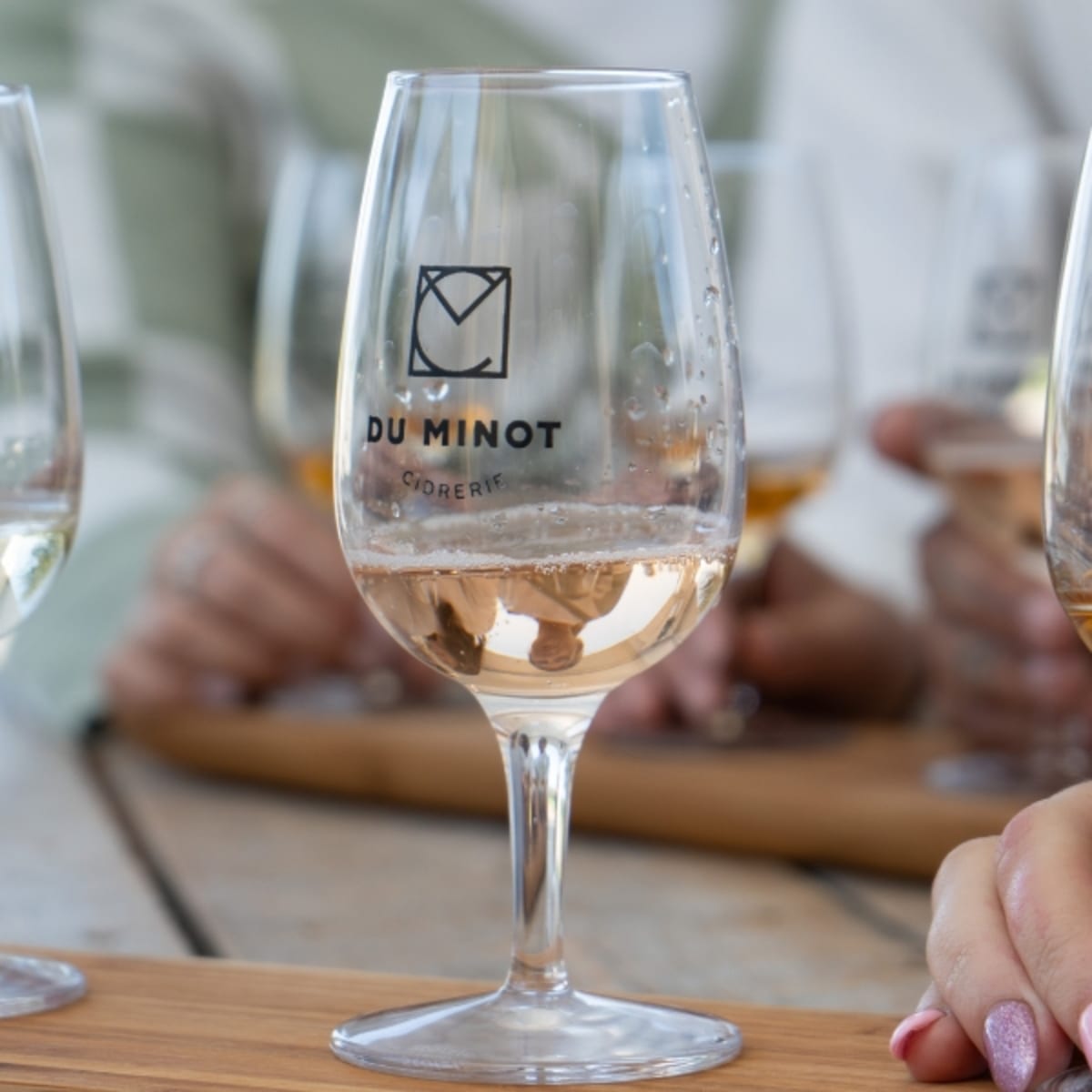 Three tasting glasses marked with the Cidrerie du Minot logo