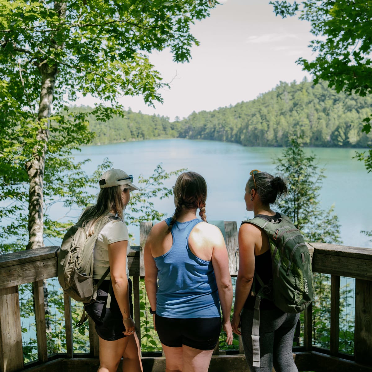 Three hikers in front of a lake in Gatineau Park. 