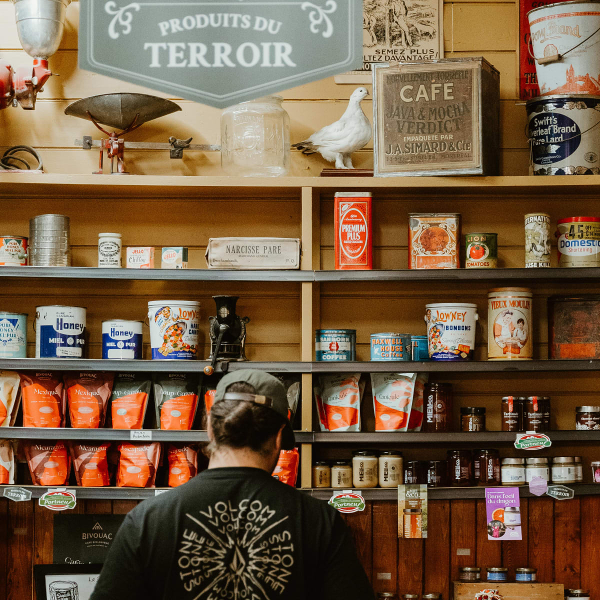 Man in front of a display of local products in a store.