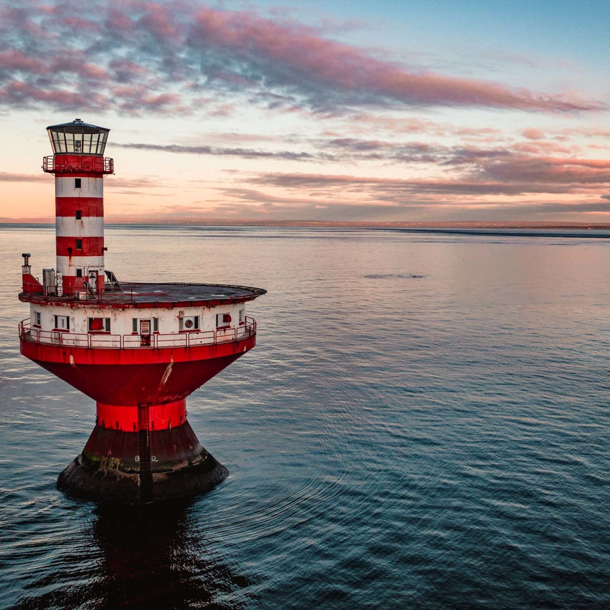 Lighthouse station in the middle of a body of water.