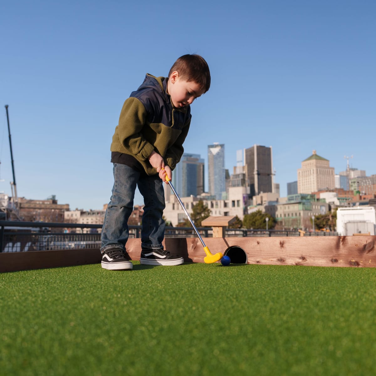 Young boy playing mini-putt