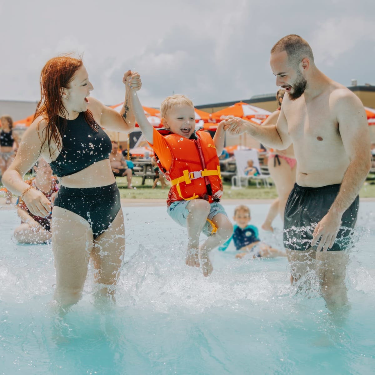 Mother, father and son in wave pool.