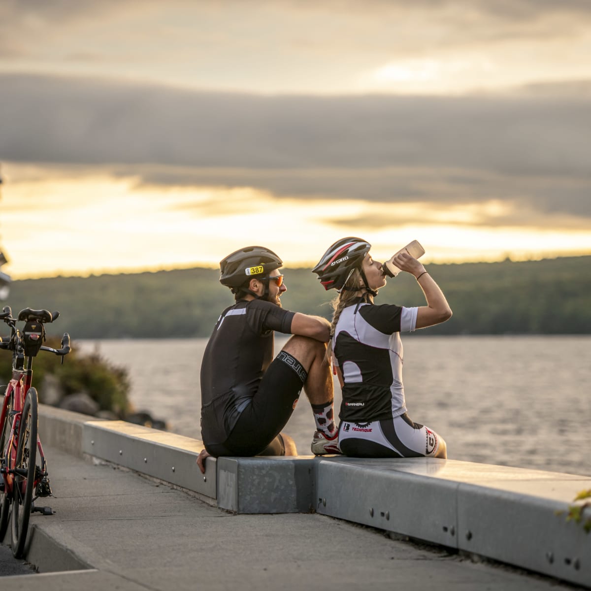 Deux cyclistes relaxant au coucher de soleil.