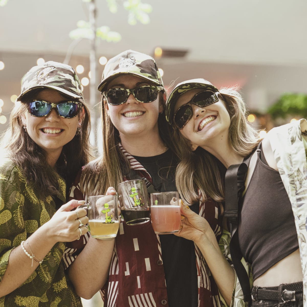 Three smiling women, beers in hand, at the Festibière de Sherbrooke. 