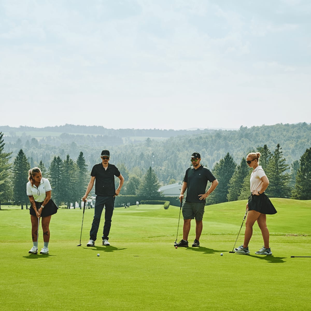 Quatre personnes sur un vert au Club de golf de Milby.
