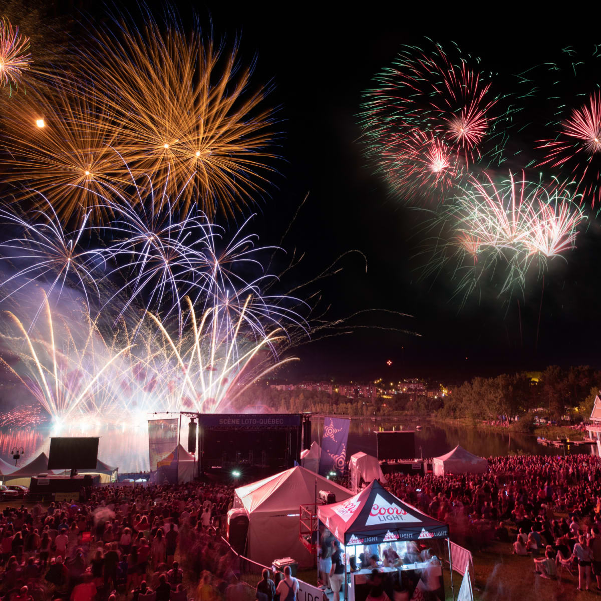 Feux d'artifice au-dessus d'une foule rassemblée lors de la Fête du Lac des Nations.
