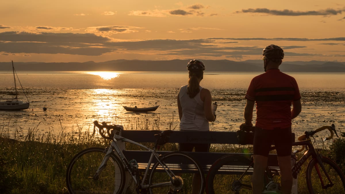 Couple de cyclistes en pause au coucher du soleil - Kamouraska