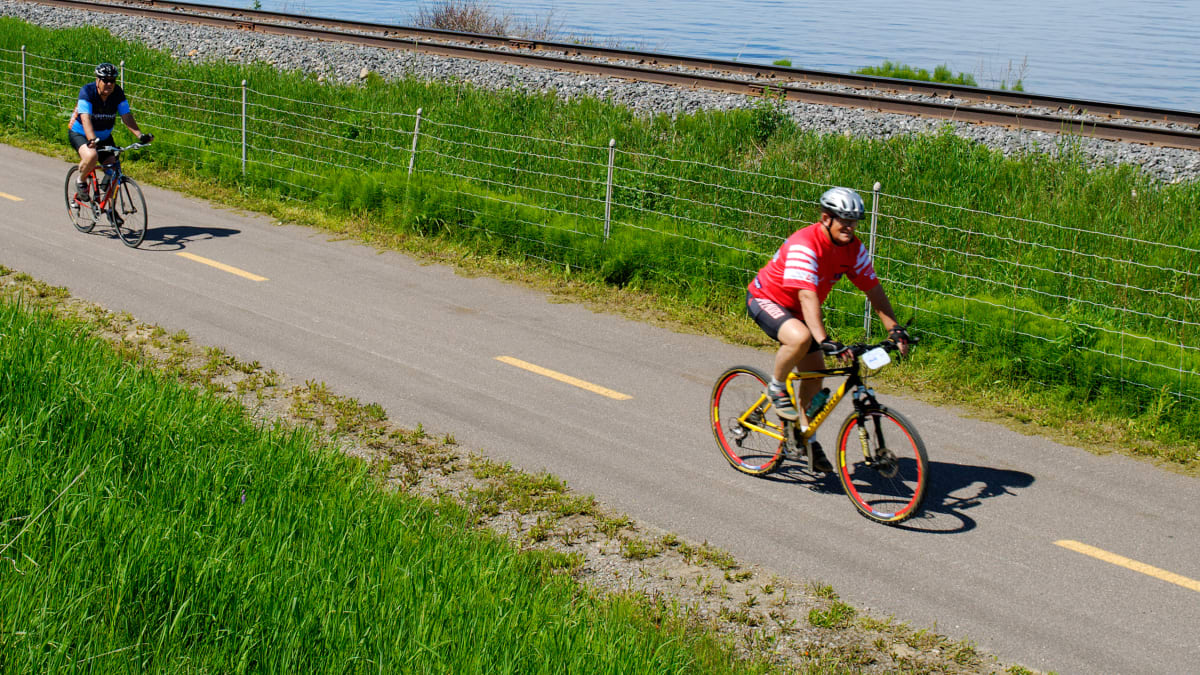 Three people on a bike path by the water