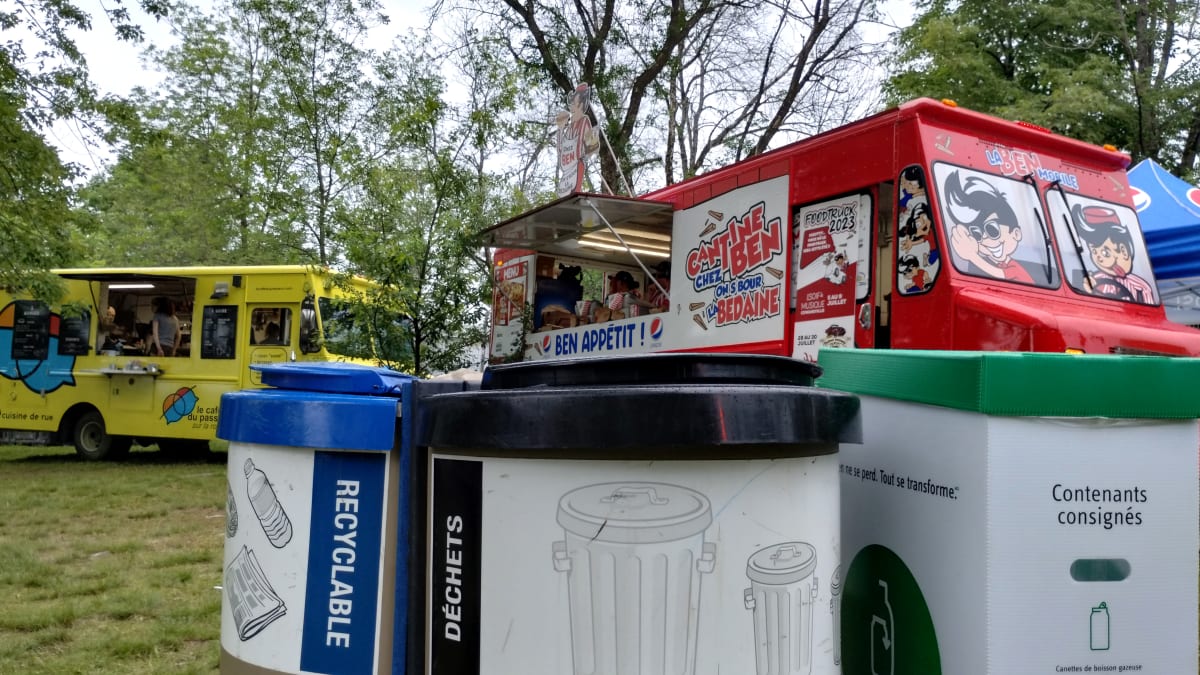 Îlot de tri des matières résiduelles devant des camions de cuisine de rue