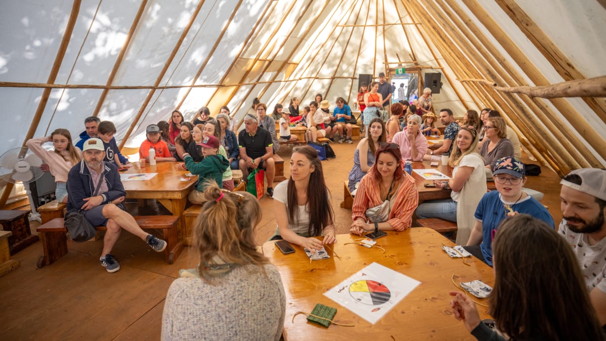 People inside a tipi at the KWE festival.
