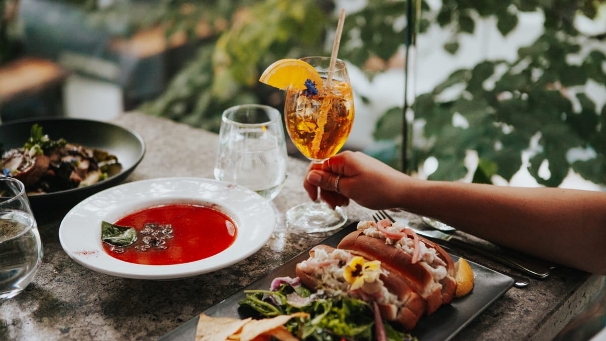 Assiette gourmande et spritz servis en plein air.