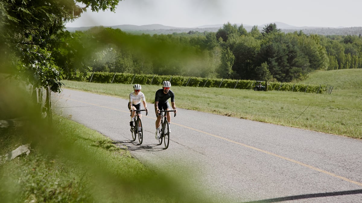 Deux personnes en vélo sur une route asphaltée.