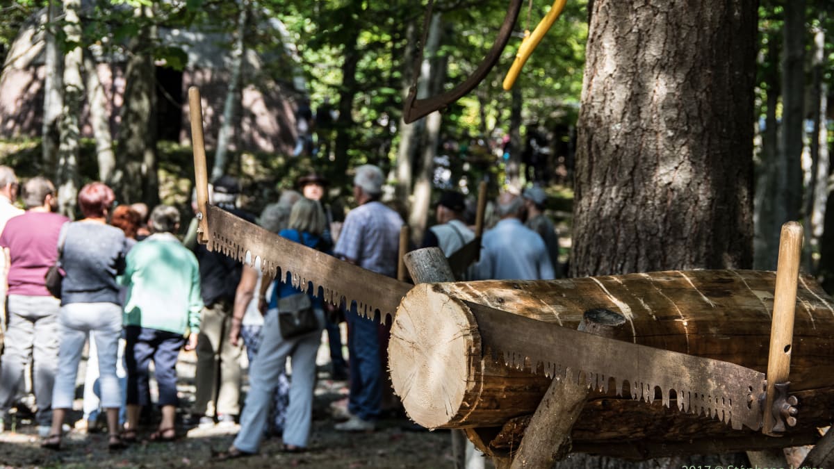 Vintage wood saw with people gathered in the back