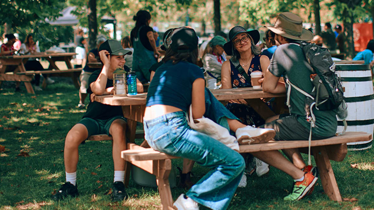 Group of people sitting at a picnic table during Les Rendez-vous gourmands
