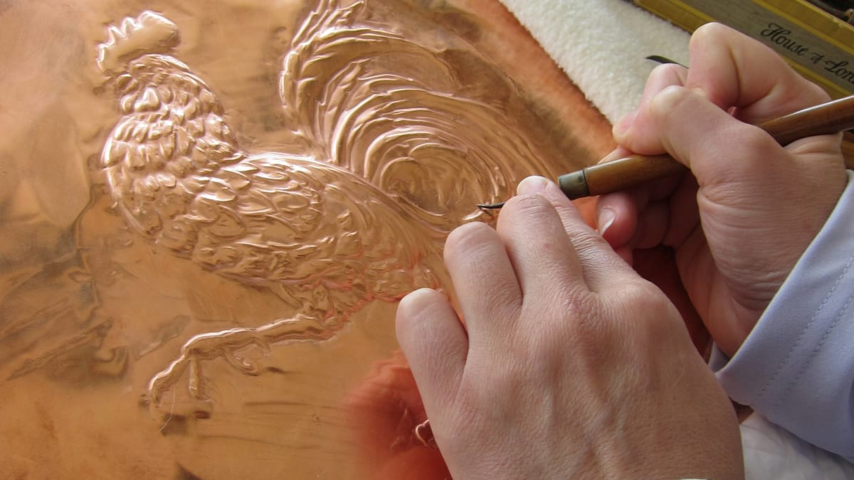 Artist embossing a sheet of copper