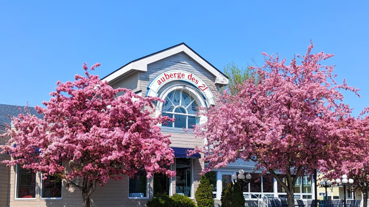 The front view of the Auberge des 21 hotel in the spring.