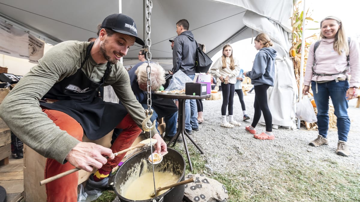 Exposant à son kiosque et festivalière qui le regarde.