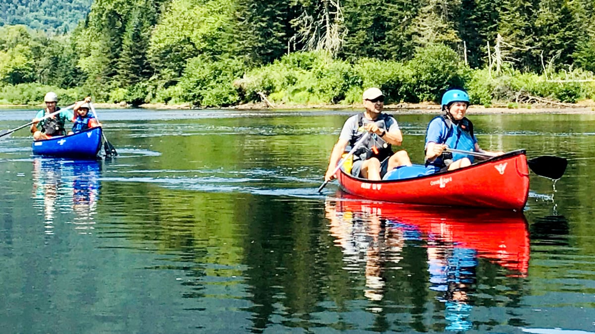 Deux couples dans deux canots sur le lac.